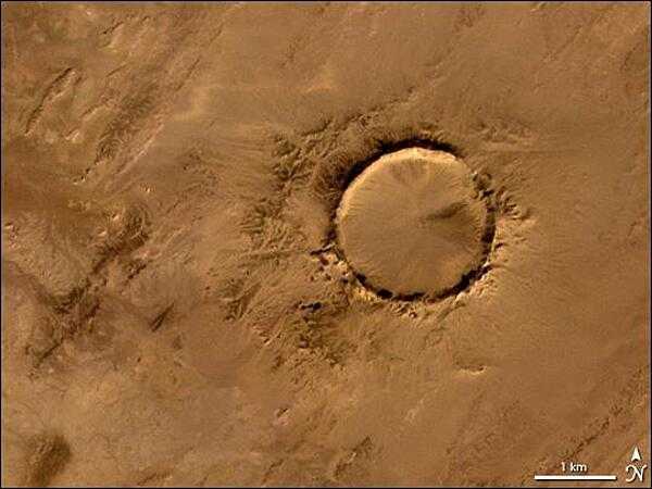 The Tenoumer crater, a nearly perfect circle in the Sahara Desert, is 1.9 km (1.2 mi) wide and sports a rim 100 m (330 ft) high. Close examination of the structure has revealed that the crater's hardened "lava" was rock that melted from a meteorite impact. Photo courtesy of NASA.