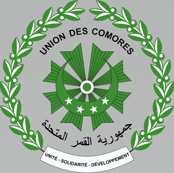 The coat of arms of Comoros, in the national colors of green and white, was adopted in 1978. The crescent and stars represent Islam, with the four stars also symbolizing the archipelago’s four main islands: Grande Comore, Mohéli, Anjouan, and Mayotte (claimed by Comoros). Above and below the sun’s rays is the name of the nation written in French and Arabic. Two olive branches, representing peace, are connected by a banner with the national motto in French, which translates as "Unity, Solidarity, Development."