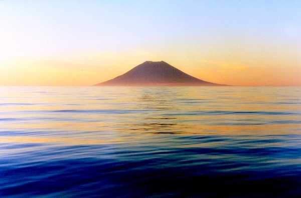 Dawn over Atlasov Island, a symmetrical volcanic cone in Russia's Kuril Island chain in the North Pacific. Photo courtesy of NOAA / Anatoly Gruzevich.