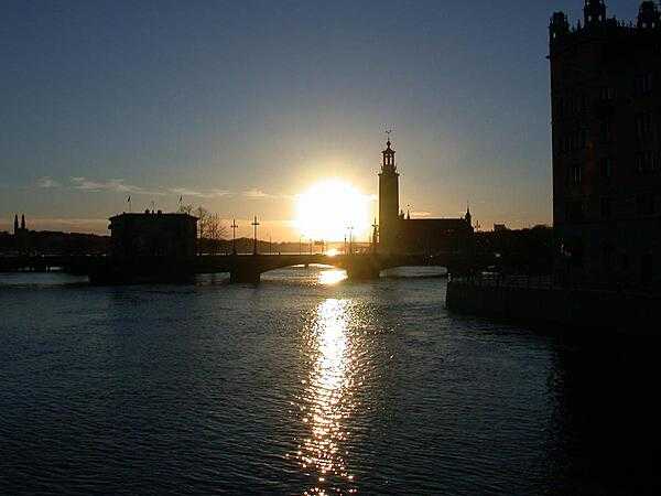 A sunset in Stockholm, Sweden, outlines the distinctive City Hall (Stadshuset) on Lake Malaren.